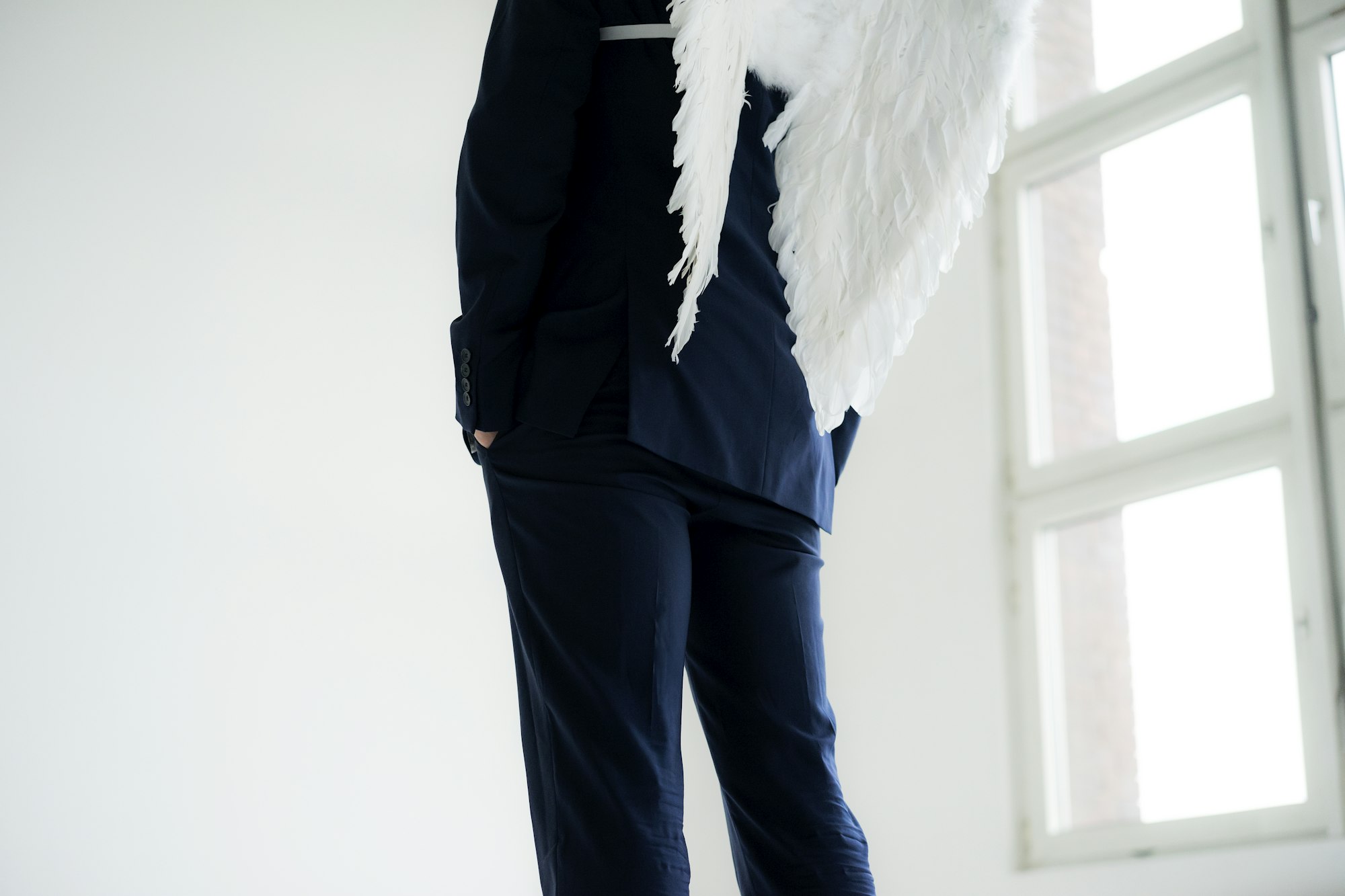 Businessman wearing suit and angel's wings, rear view