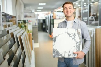 Male architect or interior designer choosing ceramic texture sample from swatch board